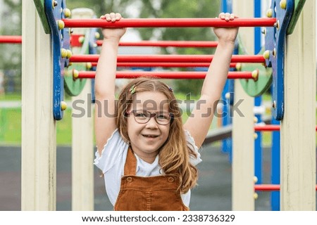 portrait of a happy smiling girl 6 years old playing on a children's playground.looks at the camera close-up. High quality photo Royalty-Free Stock Photo #2338736329