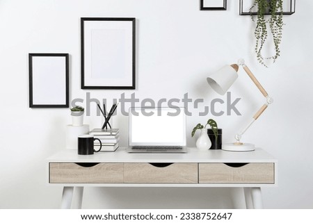 Home workplace. Laptop, lamp and stationery on white wooden desk