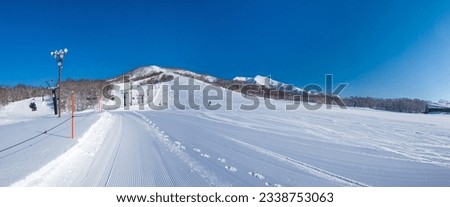 Freshly pressed piste in a quiet ski resort at early morning on a clear day (Niseko Moiwa, Hokkaido, Japan) Royalty-Free Stock Photo #2338753063