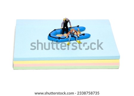Creative miniature people toy figure photography. Sticky notes installation. Ocean diving preparation above rubber dinghy boat. Isolated on white background. Image photo