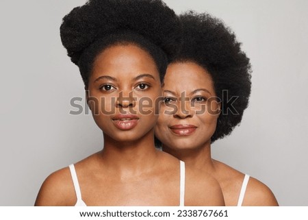 Portrait of two beautiful women. Mature lady and young model brunette together on white background Royalty-Free Stock Photo #2338767661