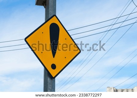Yellow caution sign against a blue sky