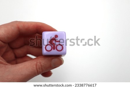 Hand holding bicycling cyclist bike ride stress relief activity dice icon sign silhouette pictogram on white background copy space Royalty-Free Stock Photo #2338776617