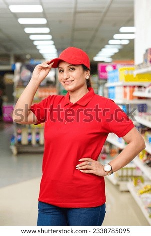 Indian woman seller in uniform and giving expression at supermarket.