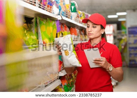 Indian saleswoman or manager checking stock at supermarket.