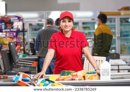 Young and confident female seller standing at supermarket. Royalty-Free Stock Photo #2338785269