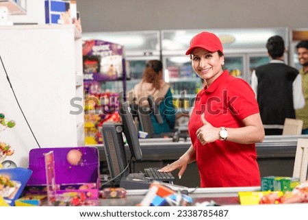 Indian woman cashier showing thumps up at supermarket. Royalty-Free Stock Photo #2338785487
