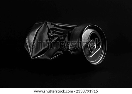 Aluminum crushed can for beverage. Low-key picture a single metallic container taken in studio with dark background. Royalty-Free Stock Photo #2338791915