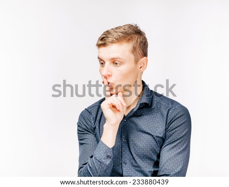 Serious executive standing with finger near his mouth - tss gesture