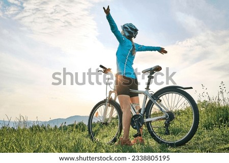 Cyclist Woman riding bike in helmets go in sports outdoors a mountain in the forest. Silhouette female at sunset. Fresh air. Health care, authenticity, sense of balance and calmness. Royalty-Free Stock Photo #2338805195