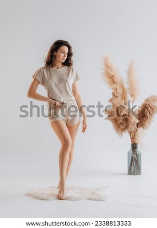Portrait of curly young woman in pajamas home wear. resting at home isolated on white background studio portrait. Relax good mood concept Royalty-Free Stock Photo #2338813333