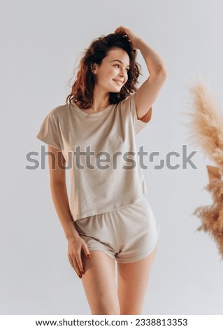 Portrait of curly young woman in pajamas home wear. resting at home isolated on white background studio portrait. Relax good mood concept Royalty-Free Stock Photo #2338813353