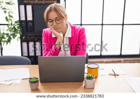 Young blonde girl business worker working with tired expression at office