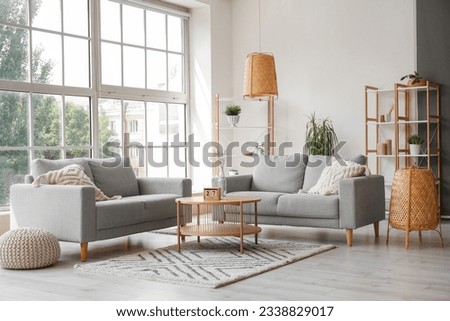 Interior of light living room with grey sofas, coffee table and large window Royalty-Free Stock Photo #2338829017