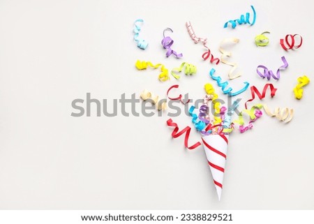 Party cone with serpentine on light background Royalty-Free Stock Photo #2338829521