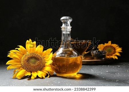 Decanter of sunflower oil on black background Royalty-Free Stock Photo #2338842399