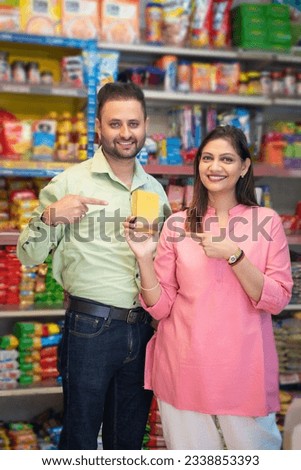 Indian couple showing product while shopping together at grocery shop.