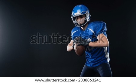 Portrait of a man in a blue uniform for american football on a black background. 