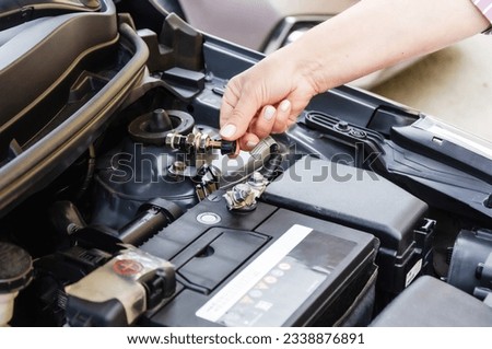 disconnecting battery in car before parking for long time. disconnects car battery terminal Royalty-Free Stock Photo #2338876891