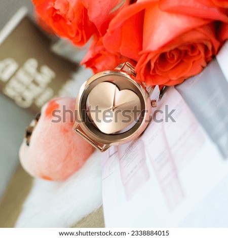 Heart-shaped rose gold watch; against the background of cup with phrase "Keep calm and drink up"