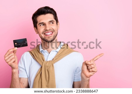 Photo of attractive bearded man wear stylish outfit hold plastic card look up empty space cool offer isolated on pink color background