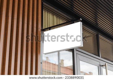 Blank white business signboard mockup. Empty illuminated shop lightbox template mounted on wall. Mock up of illuminated blank signboard. Place for text, outdoor advertising, banner.