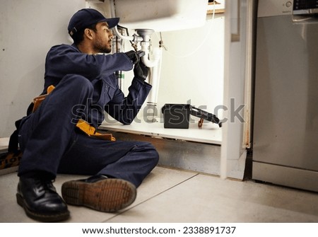 Plumbing, handyman and maintenance with man in kitchen for repair, industrial and inspection. Pipes, tools and safety with male plumber fixing sink for home improvement, drainage and water system Royalty-Free Stock Photo #2338891737