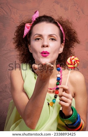 Portrait of a girl with a candy in her hand. Close-up.
