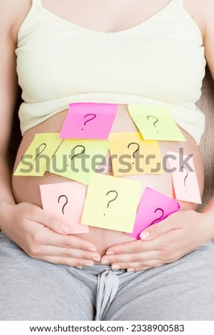 Pregnant woman belly with question mark. Pregnancy and thinking problem.