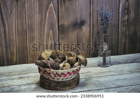 Basket with mushrooms on wooden background. Lavender in a glass flask. For restaurants and cafes. Art, background, texture. Rustic motif.