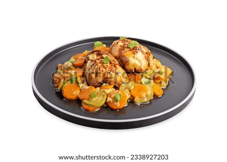 Moroccan spiced chicken with zucchini and carrots in a plate on a white isolated background. toning
