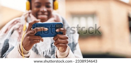 African american woman smiling confident playing video game at street