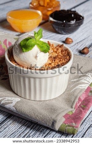Dessert. Crumble served with vanilla ice cream bean, in a baking dish. Crumble with berries, apples  in white bowls. Homemade winter dessert. close up