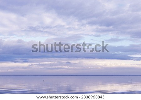 Beautiful purple blue clouds over lake, symmetric sky background, cloudscape on lake Ik, Russia. Nature abstract, cloudy sky reflected on water, calm windless weather, natural environment
