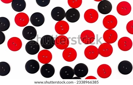 Plastic round red and black buttons on a white background