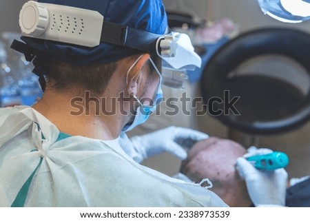 Hair transplant. Surgeons in the operating room carry out hair transplant surgery. Royalty-Free Stock Photo #2338973539