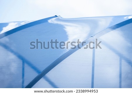 Transparent flexible roof of a greenhouse under blue sky on a daytime, background photo texture