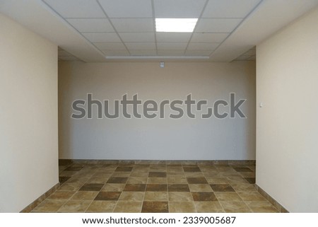A bright empty space. An empty spacious office hall, clean white walls and bright lights. Window and door in the center of the room.
