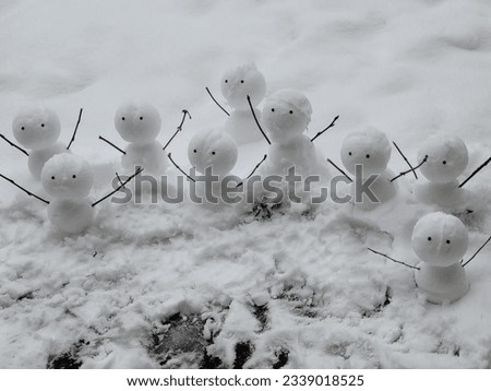Many cute little snowmen with hands up 
