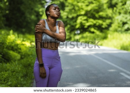 Shot of a young woman holding her arm in pain while exercising.