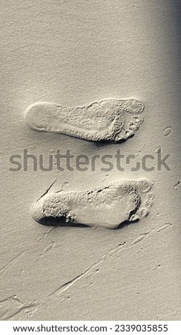 Two different left foot prints on sand