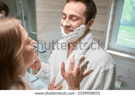 Man and woman standing in the bathroom looking at each other