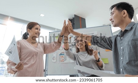 Asian female leader and ux ui designer clapping hand for successful of mobile app interface wireframe design at modern office. Creative digital development agency
