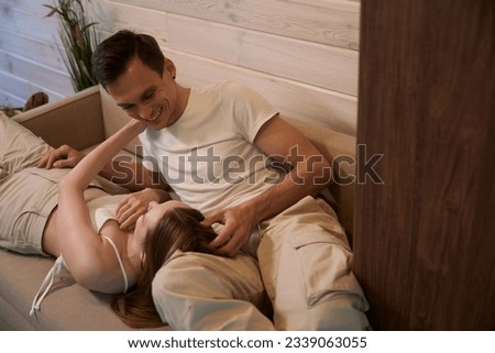 Woman put her head on the lap of the man lying on the couch