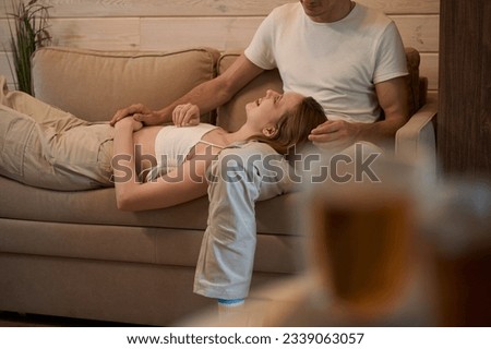 Lady lies on man lap on sofa in room