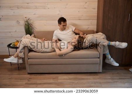 Woman lying on a sofa in a man lap