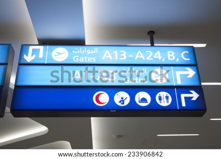 Airport direction flight sign with icons of gates, rest rooms and praying rooms dubbed in Arabic script