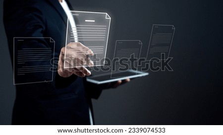 Businessman is holding digital tablet and using stylus pen signing on e document on on virtual screen against dark background.