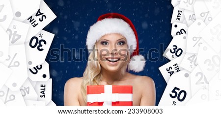Pretty woman in Christmas cap hands item at a great price, blue background