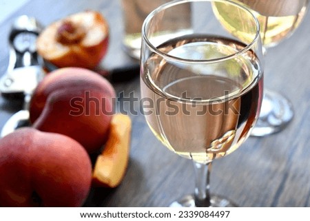 Glass of peach wine on a wooden table Royalty-Free Stock Photo #2339084497